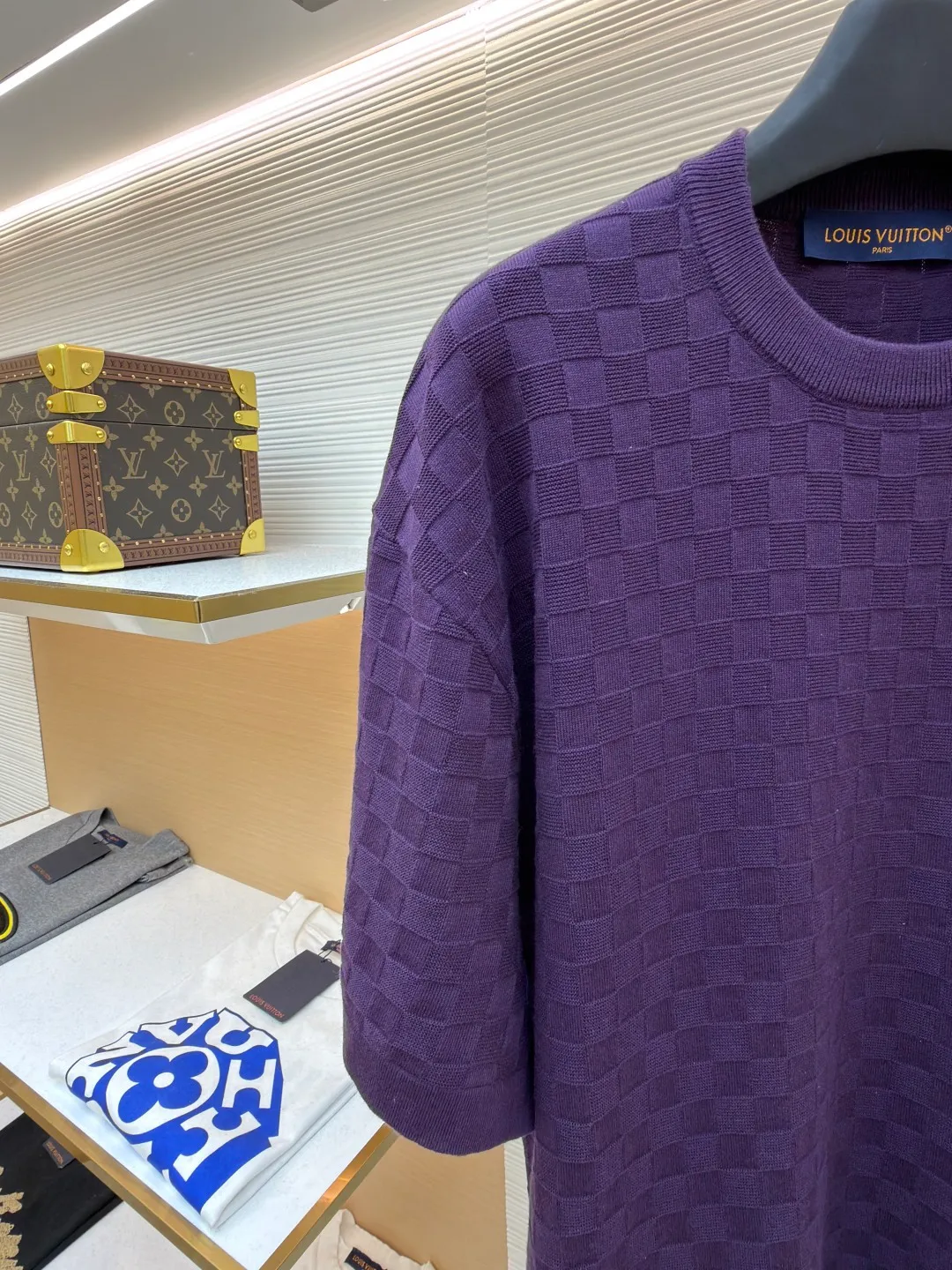 LOUIS VUITTON letter embroidered dark checkerboard jacquard short sleeves ●Original version: Purchased and developed at 9350 ●Item number: 1682319-B00 ●Fabric: 100% cotton ●Technology: jacquard knitting ●Color: Purple ●Version: Fitted version ●Weight: about 340 grams ●Size: S-M-L-XL ●Description: This Louis Vuitton purple knitted short-sleeve is made of custom worsted wool blended fabric. It is created with an 18-needle high-density weaving process using a computerized flat knitting machine to create a three-dimensional checkerboard texture. The checkered pattern is laser positioned and patterned. The size and spacing of each grid are accurate to 0.1 cm, showing a regular relief texture. The left chest uses same-color inlay embroidery technology, and the "LVM SINCE 1854" logo is embroidered with a high density of 1200 stitches/square centimeter. The embroidery thread is made of high-elastic mercerized cotton thread of the same color as the body, forming a natural texture layer with the knitted base. The neckline adopts seamless cylindrical rib technology, which is not easy to loose after high-temperature shaping treatment. The shoulders are made of seamless bonding technology to reduce the abruptness of the seams. The overall micro-profile tailoring combined with the invisible stitching technology of the side seams not only ensures the comfort of wearing, but also makes the body lines smoother. Each process has undergone multiple quality control tests by the brand to ensure the quality and durability of the craftsmanship. The overall wiring is straight and delicate, the fabric is comfortable and soft, and the color is consistent without color difference. It can be matched with the same style to create a fashionable look and control various occasions. Customized accessories, complete with three standards, same style for men and women!